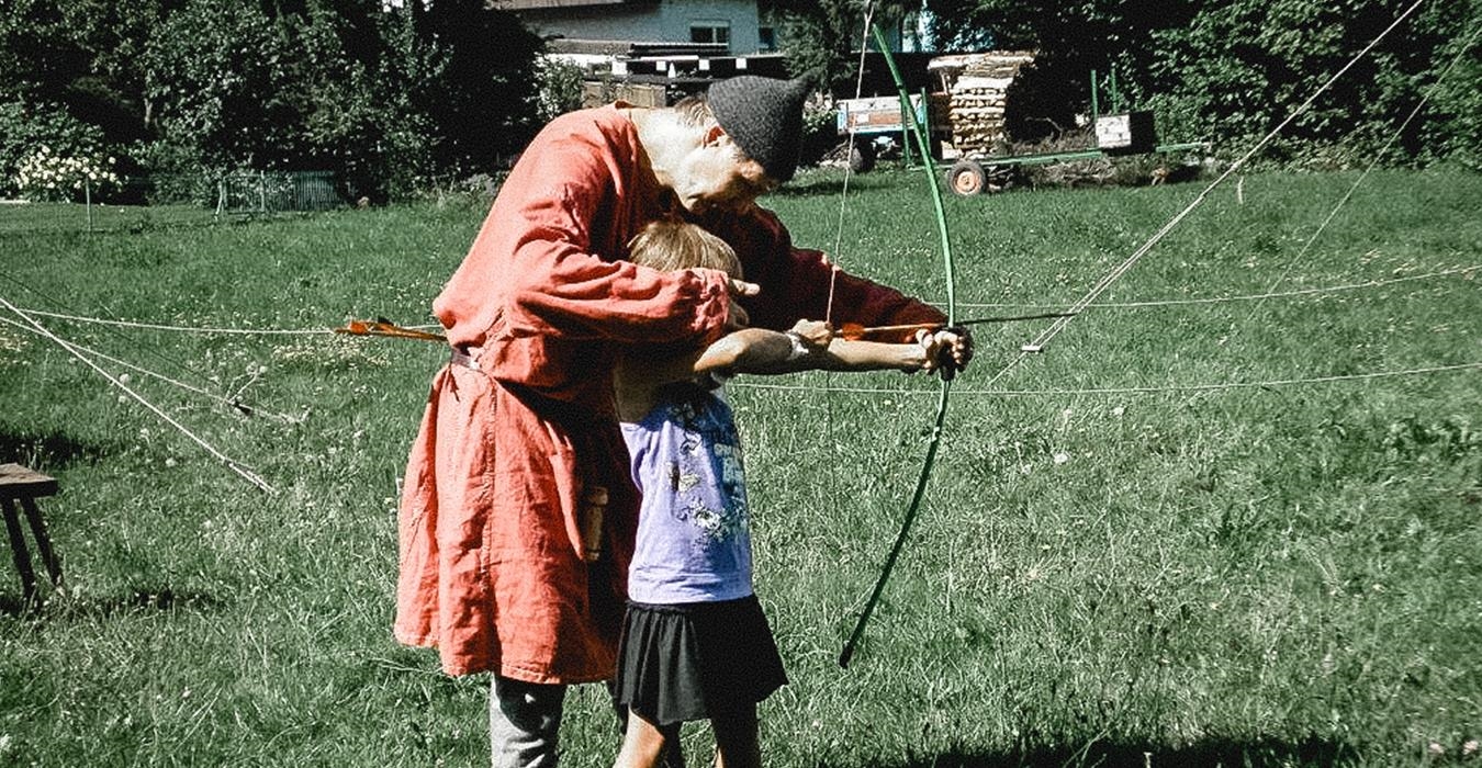 Mann und Kind beim Bogenschießen