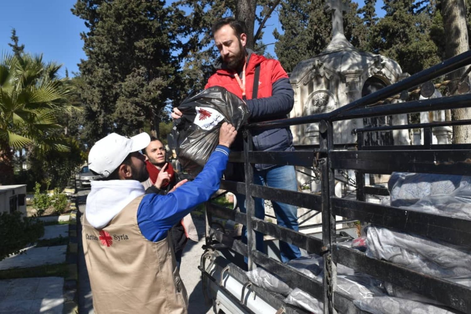 Mitarbeiter der Caritas Syrien verteilen Lebensmittelpakete im Erdbebengebiet