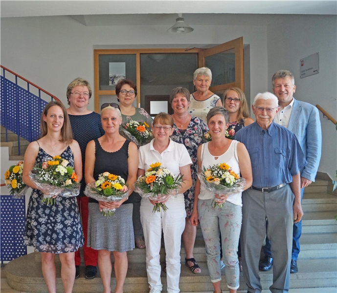 mehrere Personen, teilweise mit Blumen