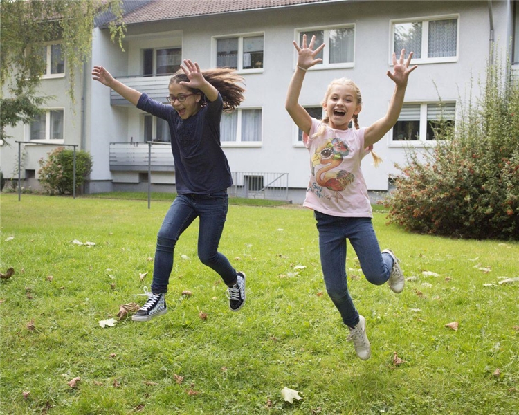 Zwei Mädchen springen freudig in die Luft