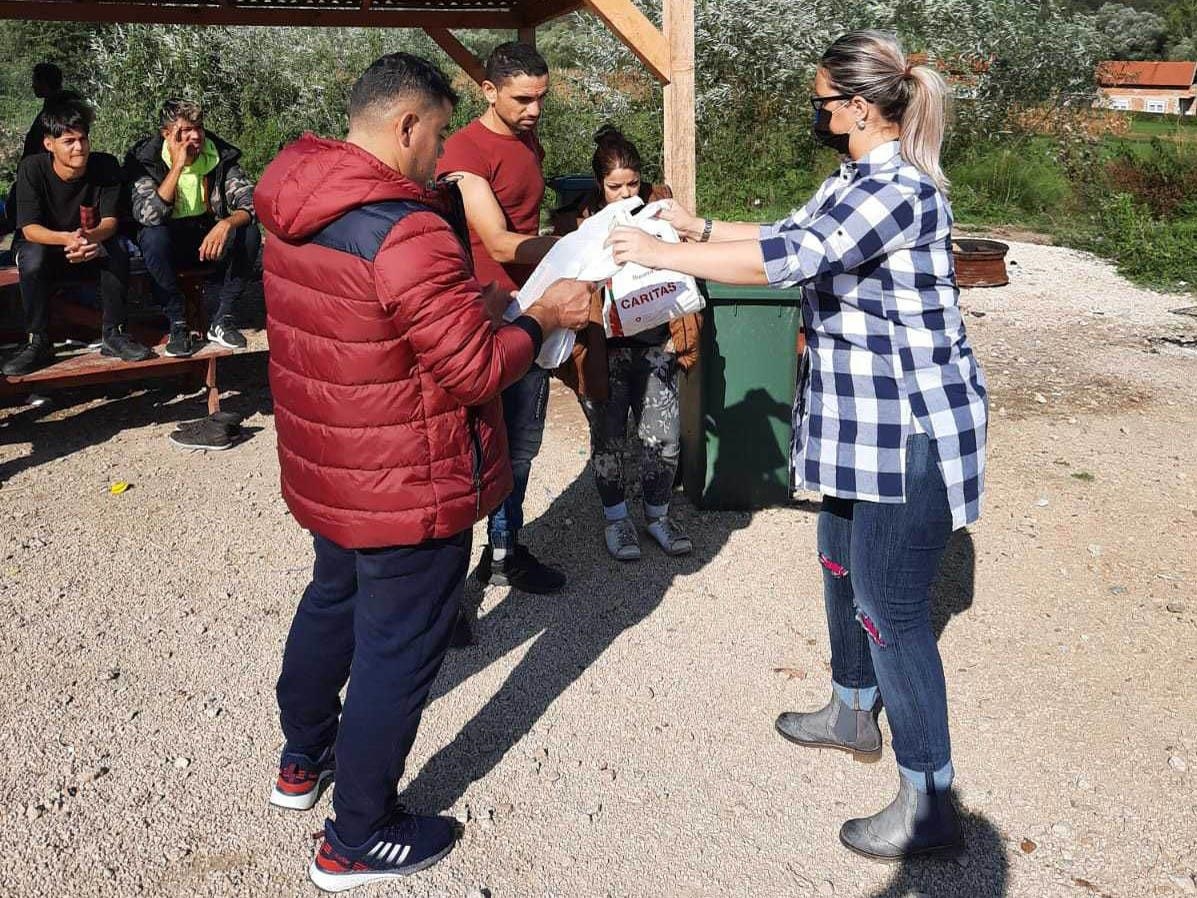 Frau übergibt Caritaspaket an Flüchtlinge (Foto: Caritas Bosnien Herzegowina)