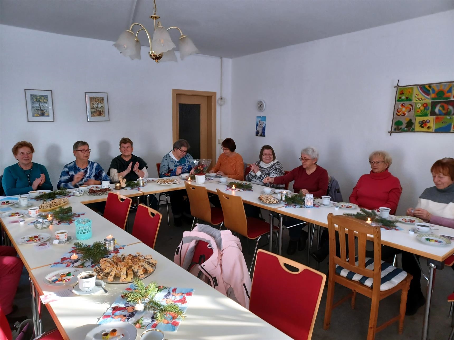 Senioren sitzen an einem Tisch und feiern
