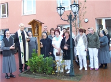 Segnung der Figur des heiligen Josef im Innenhof mit Priester und Mitarbeitern des Hauses