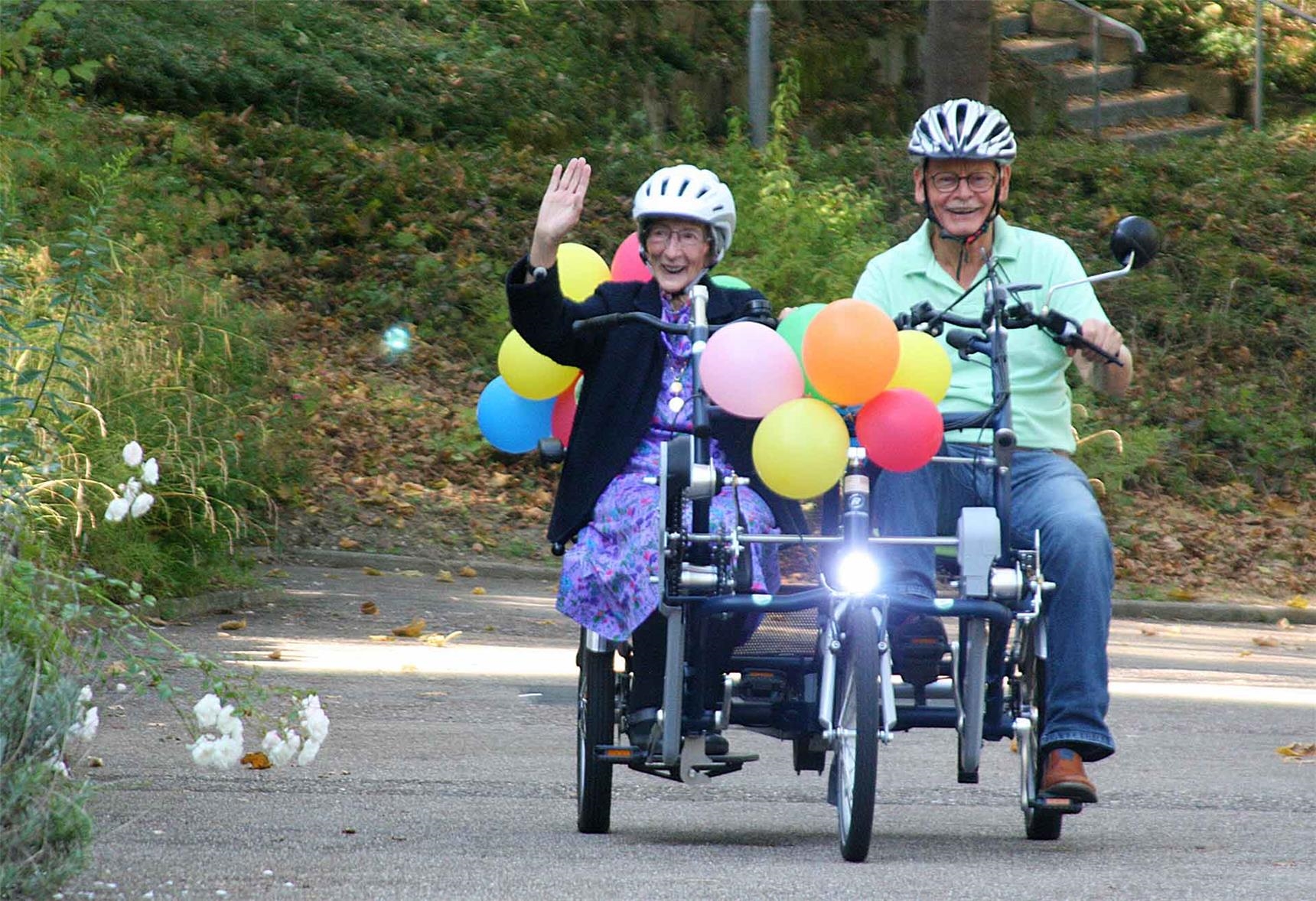 eine Frau und ein Mann sitzen auf einem Tandem-Fahrrad