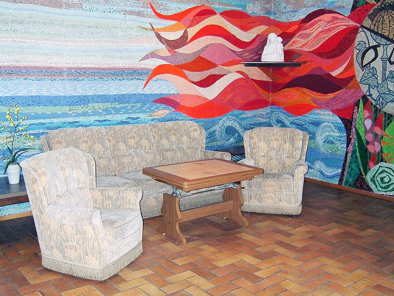 Aufwändig gestaltetes und farbenprächtiges Wandmosaik mit gemütlichen Sitzgelegenheiten. 