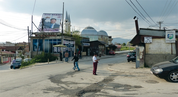 Eine Straßenkreuzung in Shukta (Mazedonien) mit einigen Personen auf der Fahrbahn (Alexander Richter)
