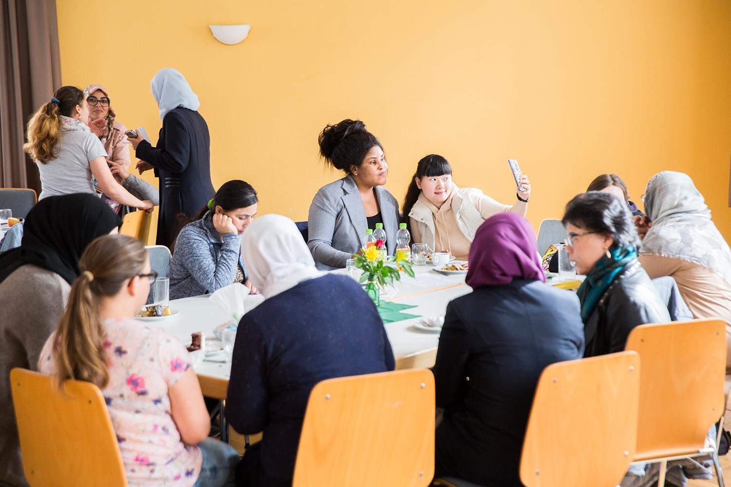 Eine Gruppe von Frauen sitzt an einem großen Tisch beim Frühstück (Deutscher Caritasverband e. V. / Sebastian Pfütze)