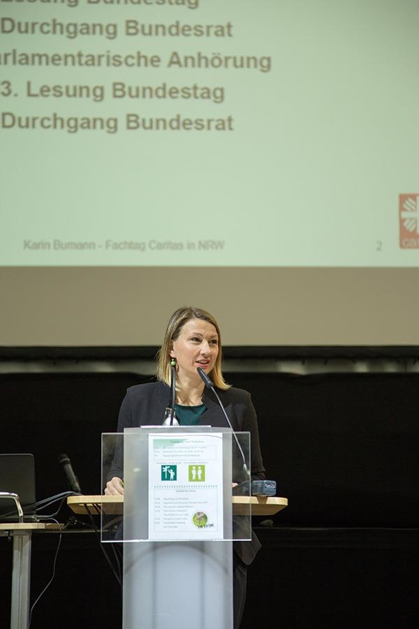 Karin Bumann steht vor einem Pult und hält bei der Fachtagung der Caritas in NRW zum BTHG in Gelsenkirchen eine Rede (Mello)