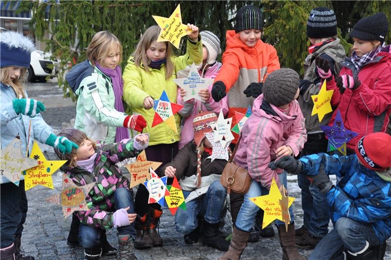 eine Gruppe Kinder hält gelbe Pappsterne in den Händen (Kinderstiftung Ravensburg)