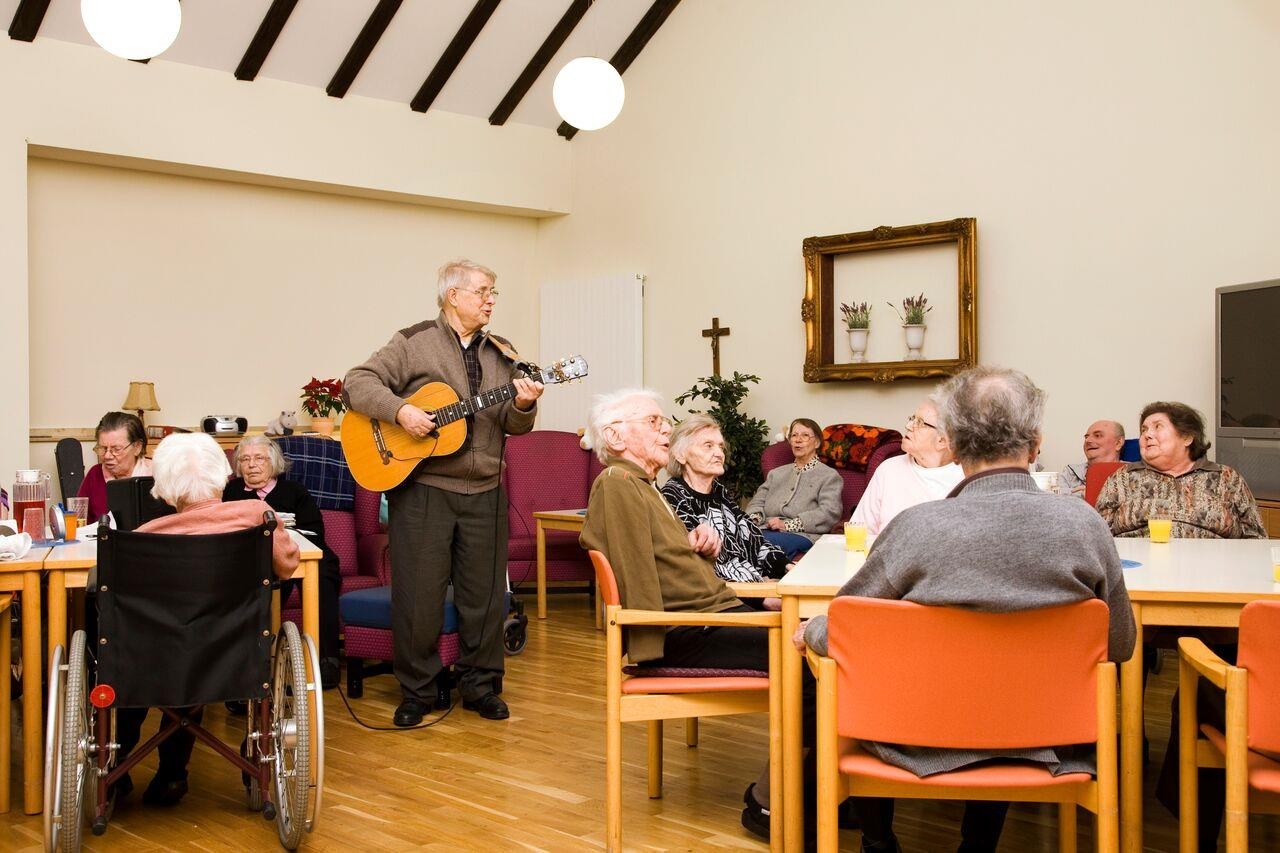 Die Bewohner musizieren gemeinsam; einer spielt Gitarre 