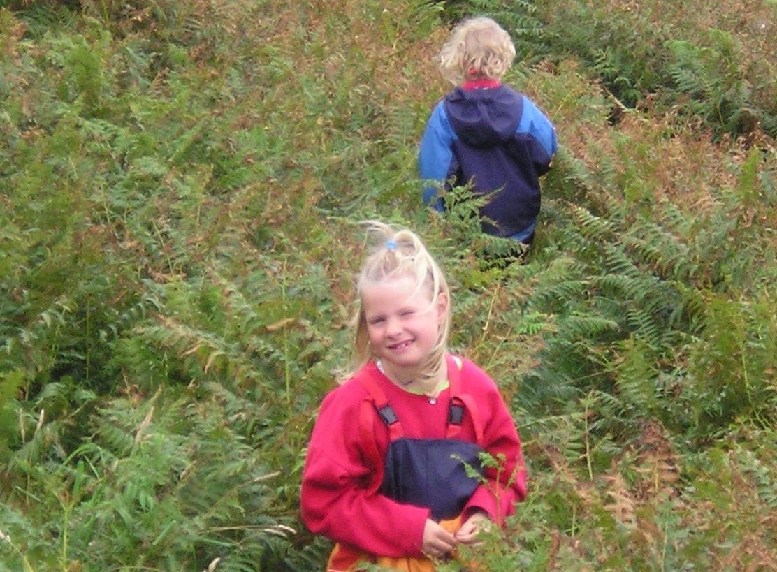Zwei Kinder spielen im Wald. (Deutscher Caritasverband e.V./kbö)