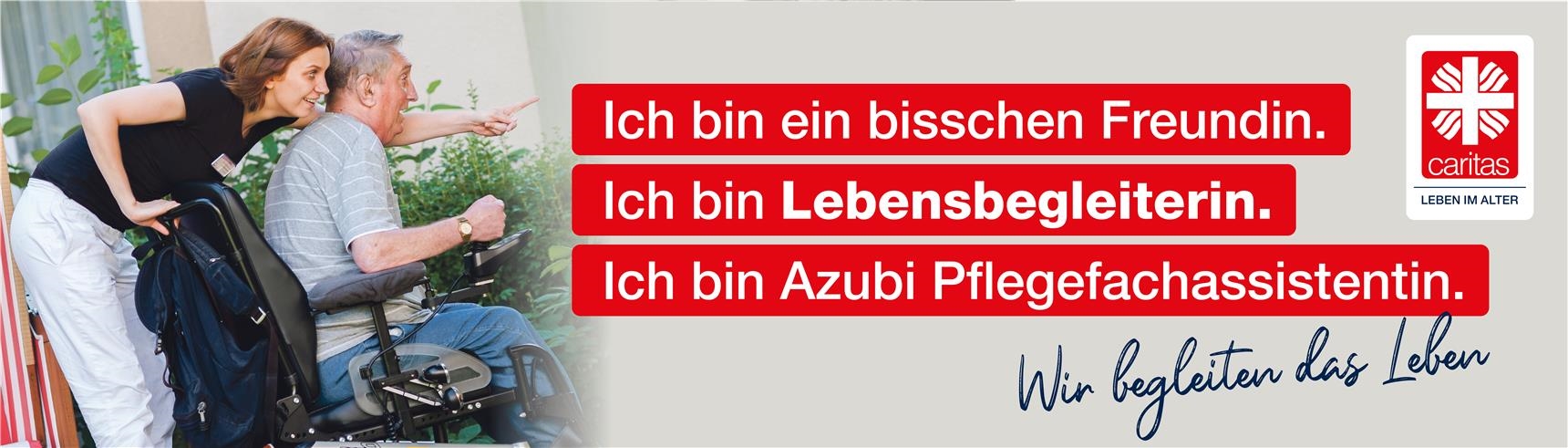 Die Pflegefachassistentin ist Hauptansprechperson für die Seniorin. Die junge Auszubildende schiebt einen Senior im Rollstuhl und zeigt auf etwas in der Ferne. Beide haben Freude.