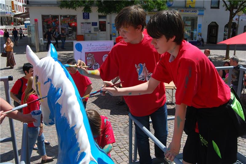 Zwei Jungs bemalen die Pferdeskulptur (Caritas Speyer)