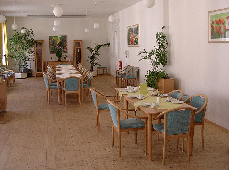 Moderner Speisesaal mit türkisfarbenen Stühlen und Holz-Dielenfußboden. 