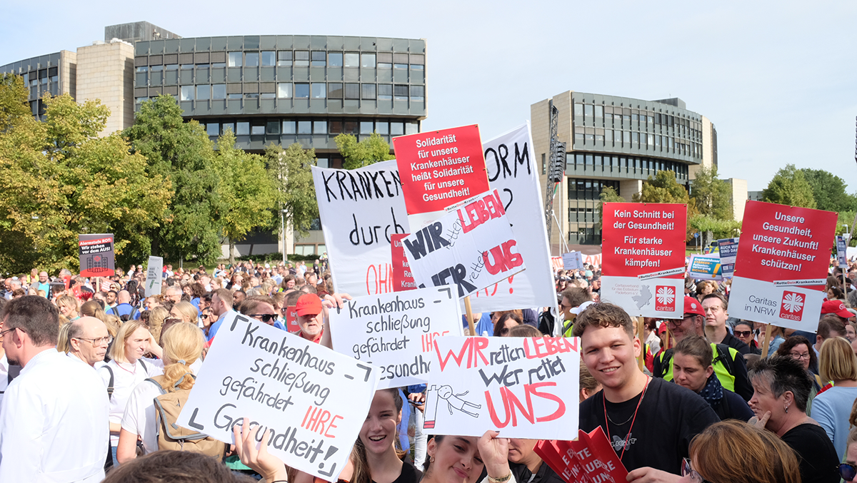 Demonstraten, die bei einer Kundgebung zur Krankenhausfinanzierung vor dem Düsseldorfer Landtag stehen und dabei Schilder und Transparente hochhalten (Foto: Markus Lahrmann)