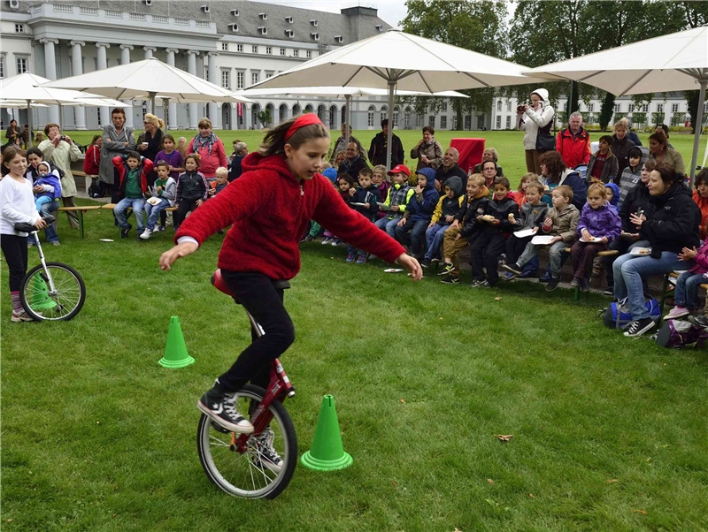 Ein Mädchen zeigt auf einem Einrad eine kleine Darbietung vor Zuschauern. (Dietmar Guth)