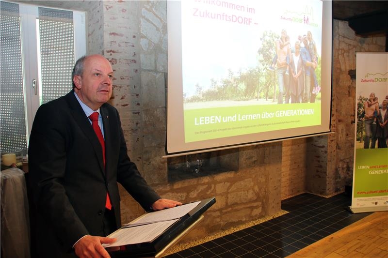 Ein Mann steht vor einem Podium und hält eine Rede.