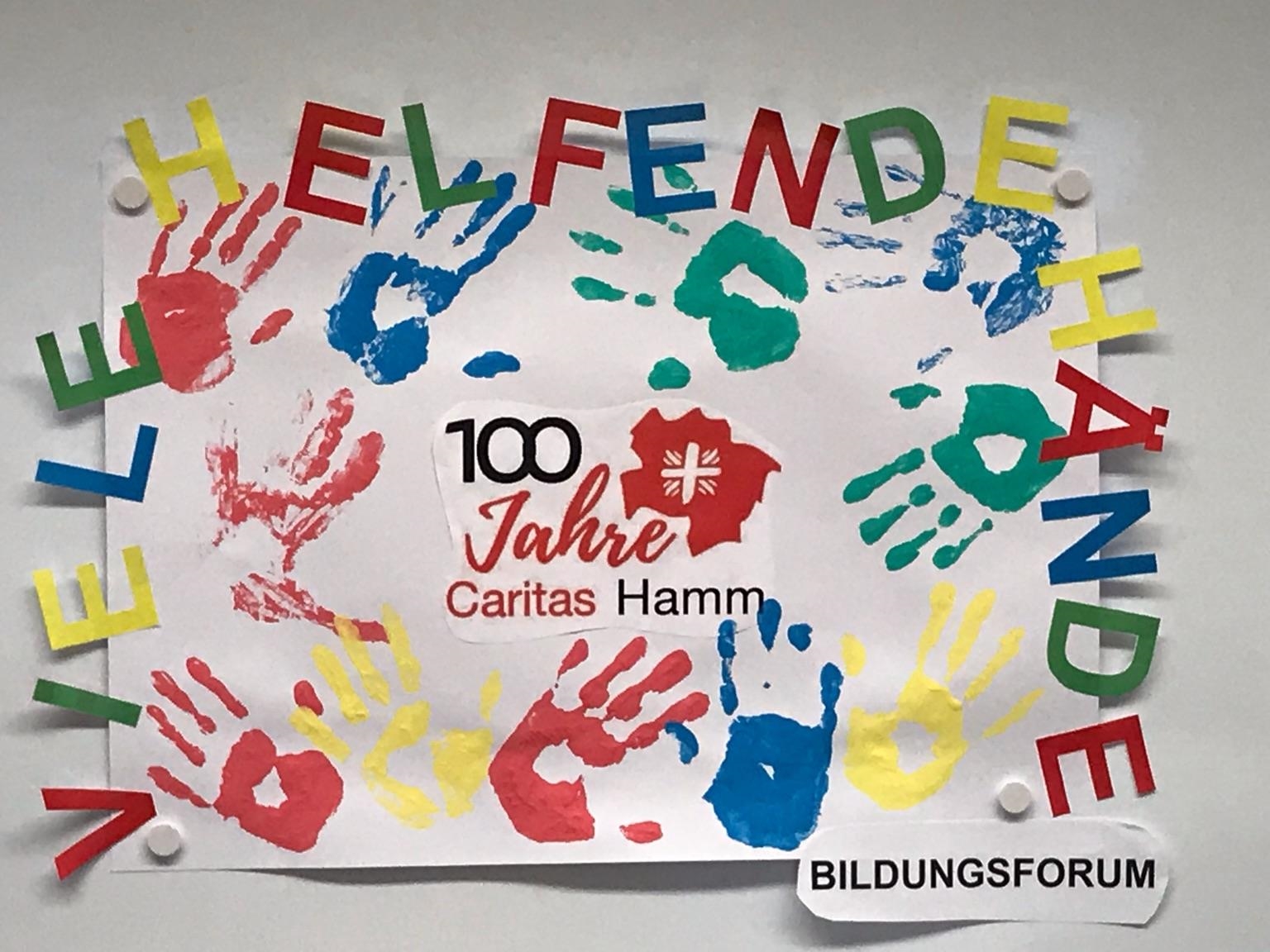 Weißes Plakat mit vielen Handabdrücken in rot, grün, blau und gelb und dem Text Viele Helfende Hände (Caritas Bildungsforum)