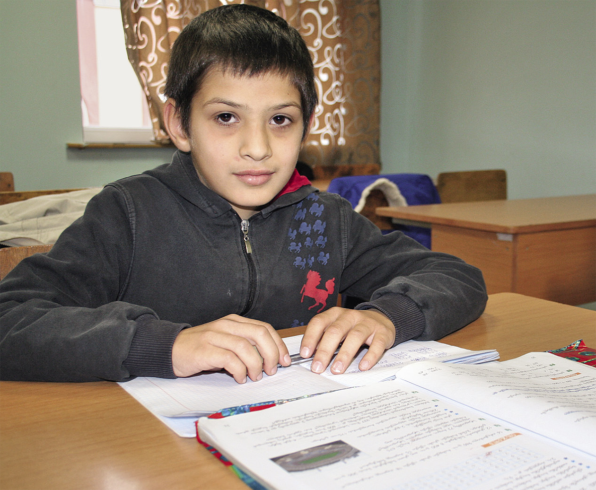 Ein georgischer Junge sitzt in einem Klassenzimmer vor seinem Hausaufgaben (Markus Lahrmann)