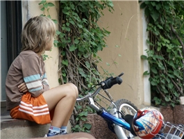 Ein traurig aussehender Junge mit Fahrrad / Deutscher Caritasverband