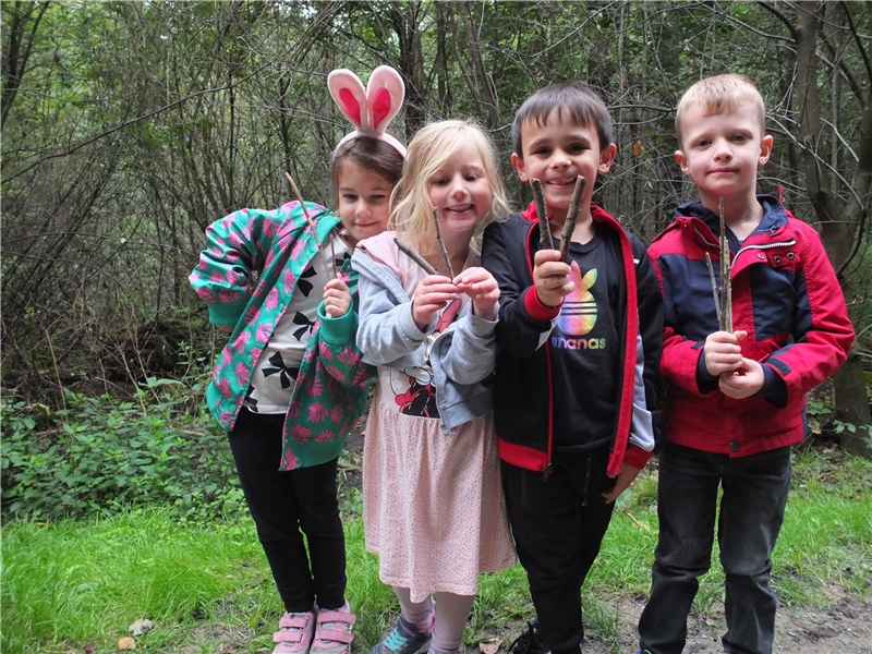 Vier Kinder auf einem Waldweg. Sie schauen in die Kamera