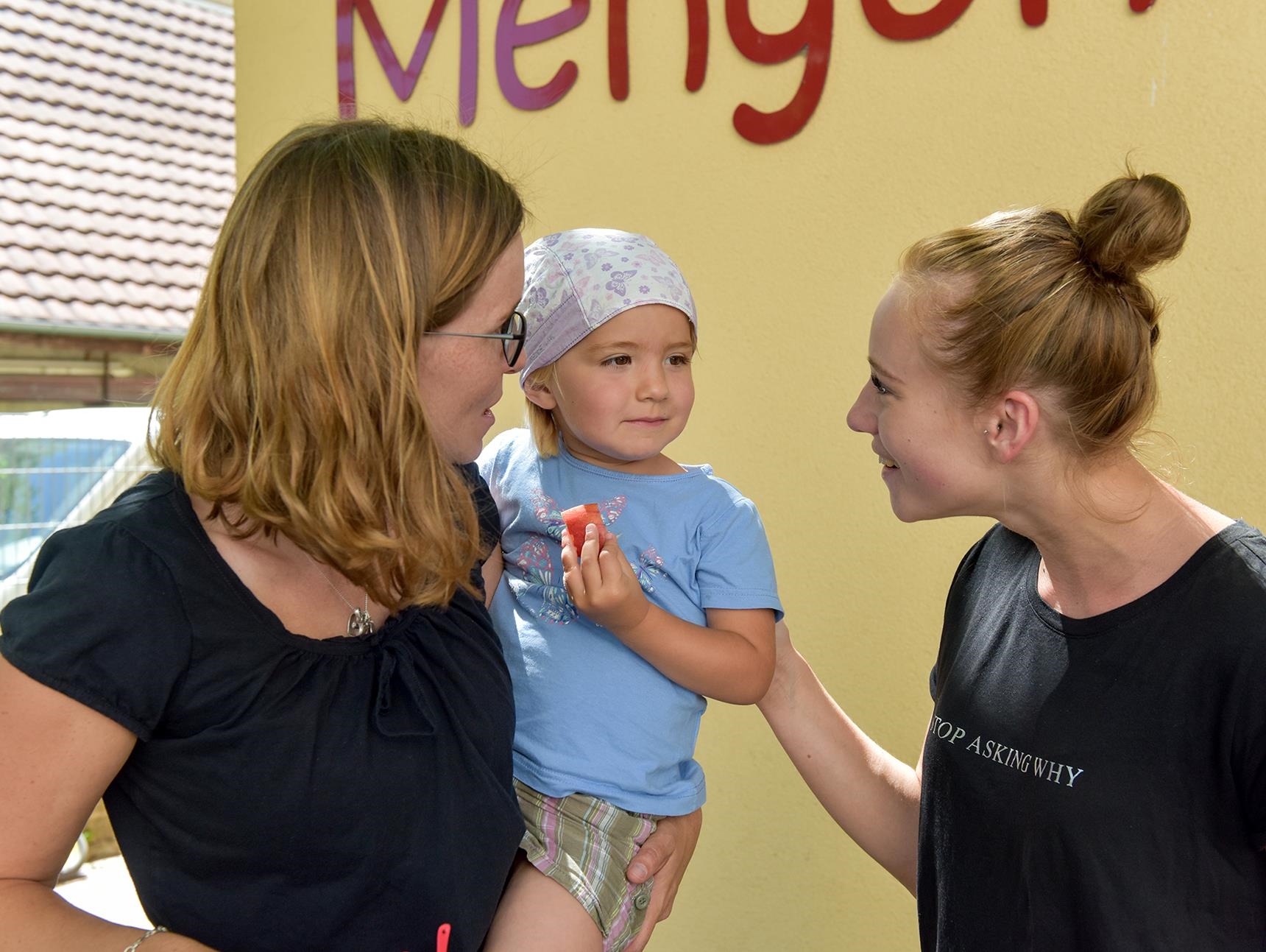 Kind mit Erzieherin und Mutter vor Kindergarten (DCV/KNA)