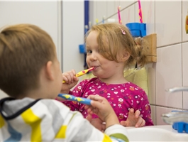 Ein Mädchen und ein Junge stehen am Waschbecken und putzen sich die Zähne / Dietmar Wäsche