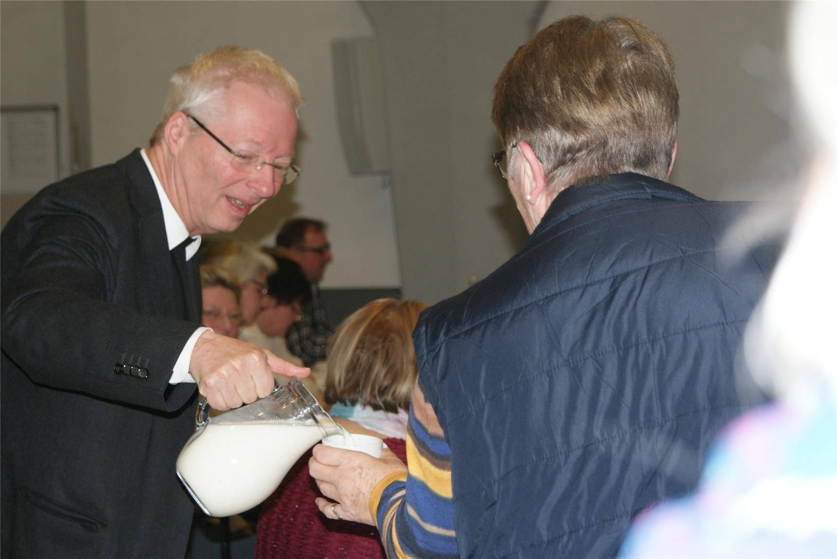 Pfarrer Dybowski schenkt Milch aus (© CKD-Bundesverband)