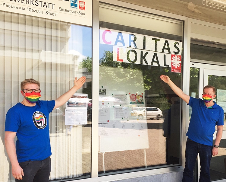 Die Herren Leon Reinel und Peter Grünig in bunten Schutzmasken und bunter Kleidung vor der Stadtteilwerkstadt Eberstadt-Süd (Caritasverband Darmstadt e. V.)