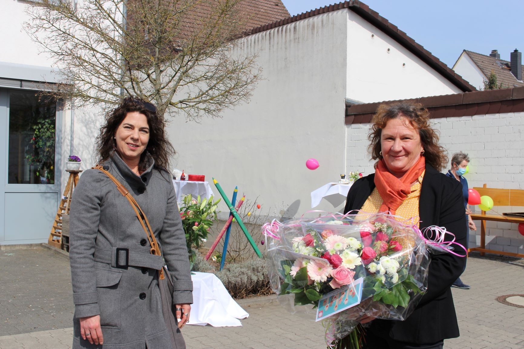 Eine Frau bekommt von einer anderen Frau einen Blumenstrauß. (Caritasverband Darmstadt e. V.)