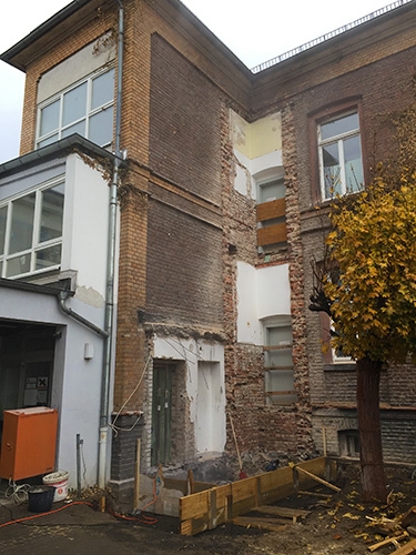 Außenaufnahme abgerissenes Treppenhaus, drei mit Brettern nach außen gesicherte Türen (Caritasverband Darmstadt e. V. / M. K. Triebel)