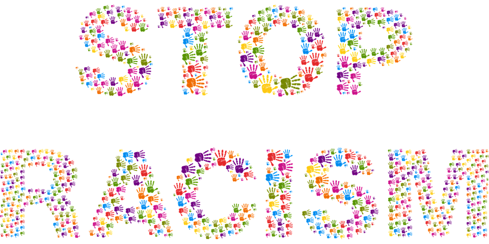 Grafik: Aus bunten Handabdrücken geformter Schriftzug Stop Racism (Gordon Johnson als GDJ auf Pixabay)