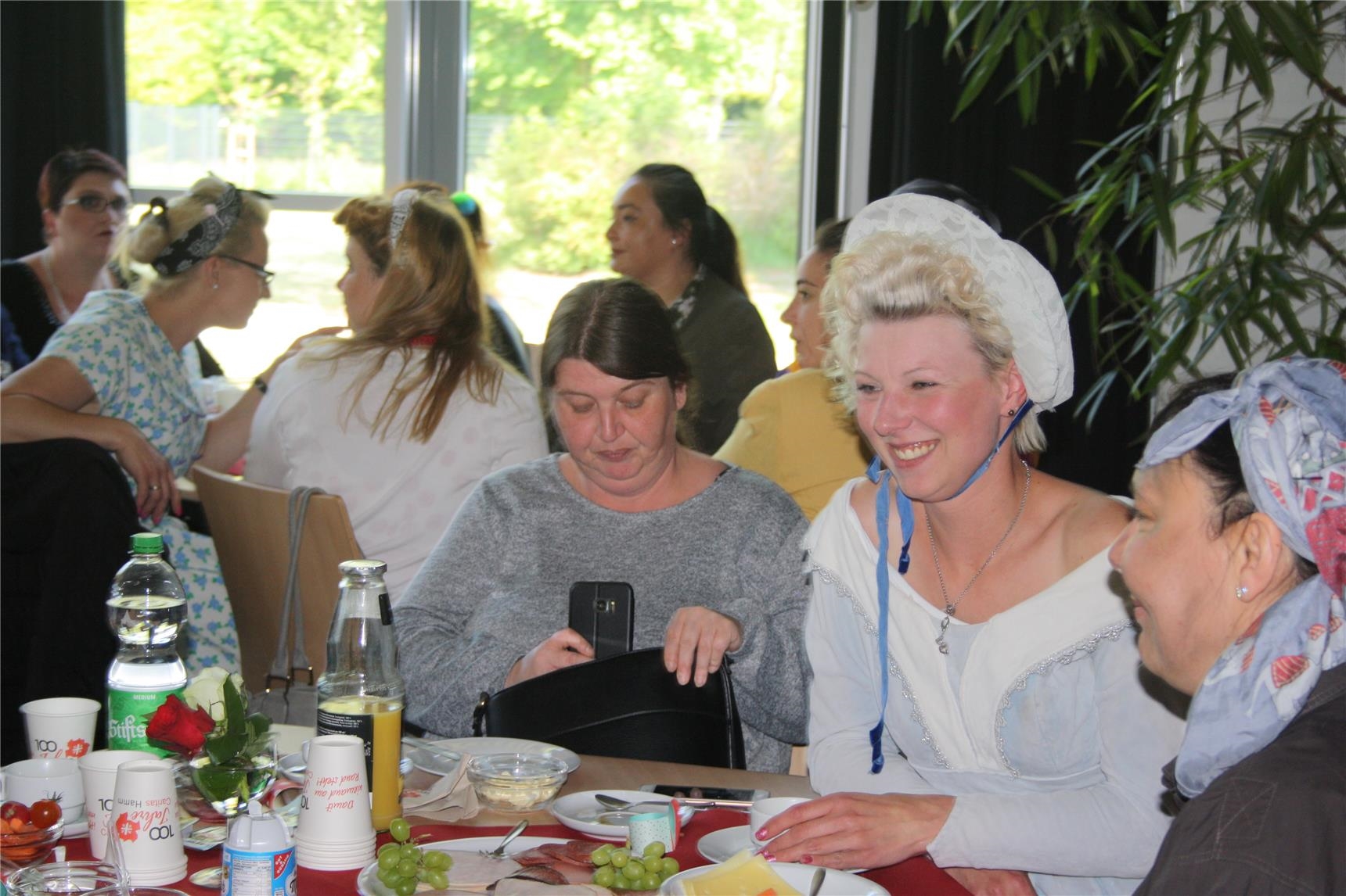 Mehrere Frauen sitzen an gedeckten Frühstückstischen (Caritas Hamm)