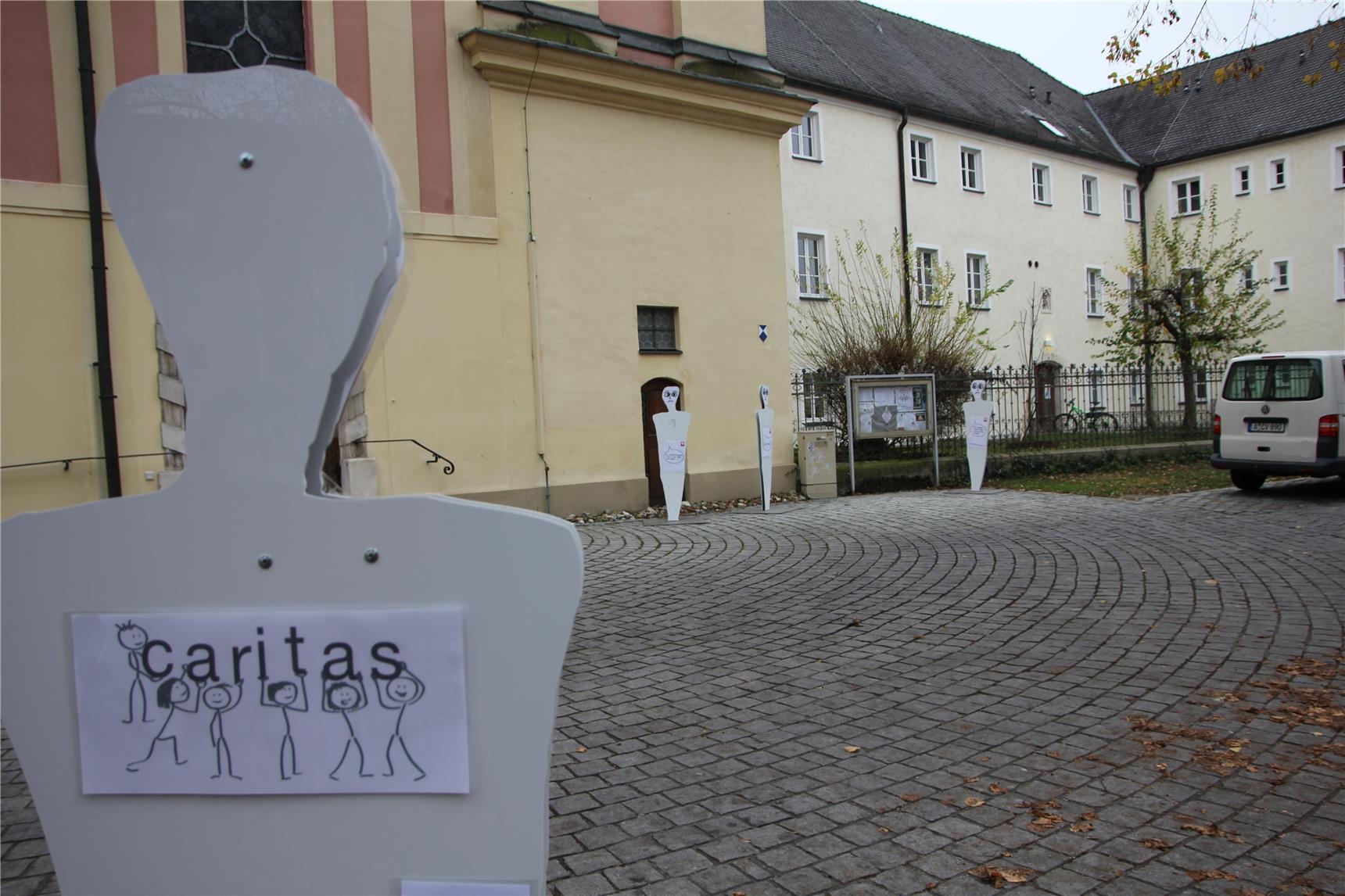 Lebensgroße Figuren auf dem Vorplatz der Heilig-Geist-Kirche in Neuburg machen auf Armutssituationen aufmerksam.  (Bernhard Gattner)