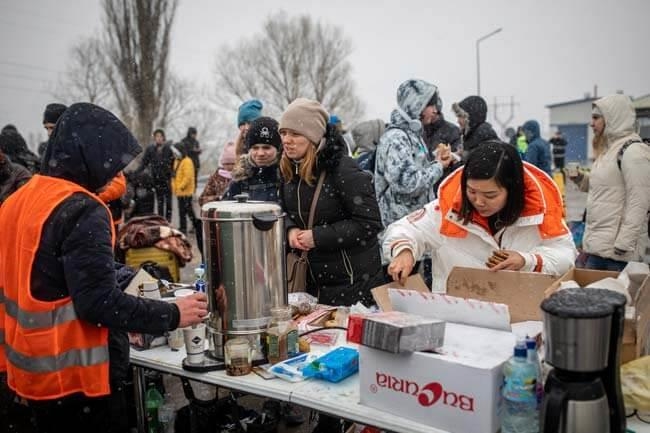 Menschen erhalten heiße Getränke und Essen (Foto: Marijn Fidder/ Caritas international)