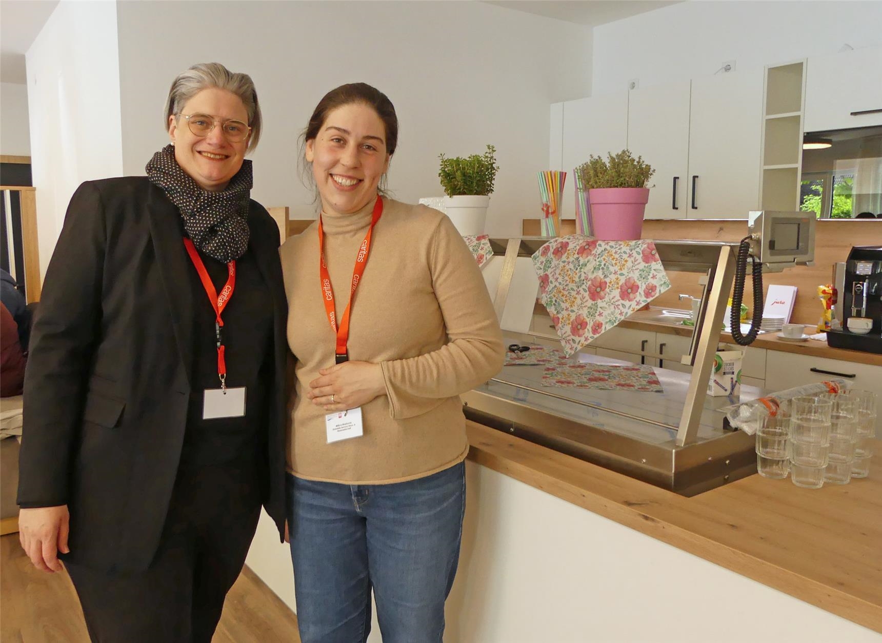 Gruppenbild im Quartierscafé von Haus Raphael mit der Geschäftsführerin des Bereichs "Gesundheit & Pflege" und einer Mitarbeiterin (Foto: © Caritas Offenbach / Sabine Schilha)