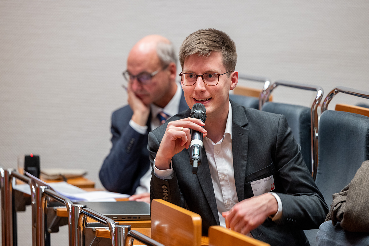 Ein Teilnehmer hält ein Mikrofon in der Hand und stellt eine Frage bei der Podiumsdiskussion beim 1. Kath. Krankenhaustag NRW am 10.11.2021 in Essen (Foto: Achim Pohl)
