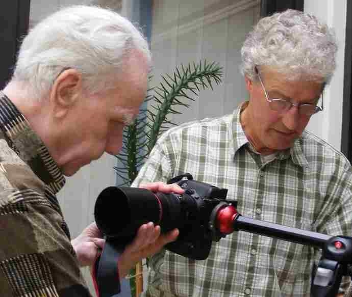 Zwei Fotografen justieren ihre professionelle Kamera-Ausrüstung. (Caritasverband Rhein-Hunsrück-Nahe)