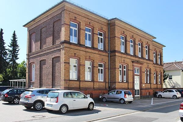 Zweistöckiges Gebäude mit Parkplätzen drumherum (Caritasverband Darmstadt e. V.)