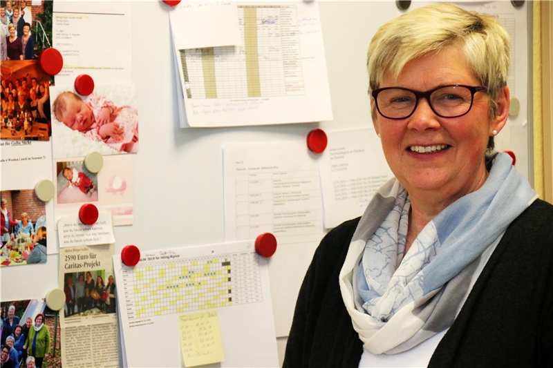 Das Foto zeigt eine Frau vor einer bunt bestückten Pinwand.