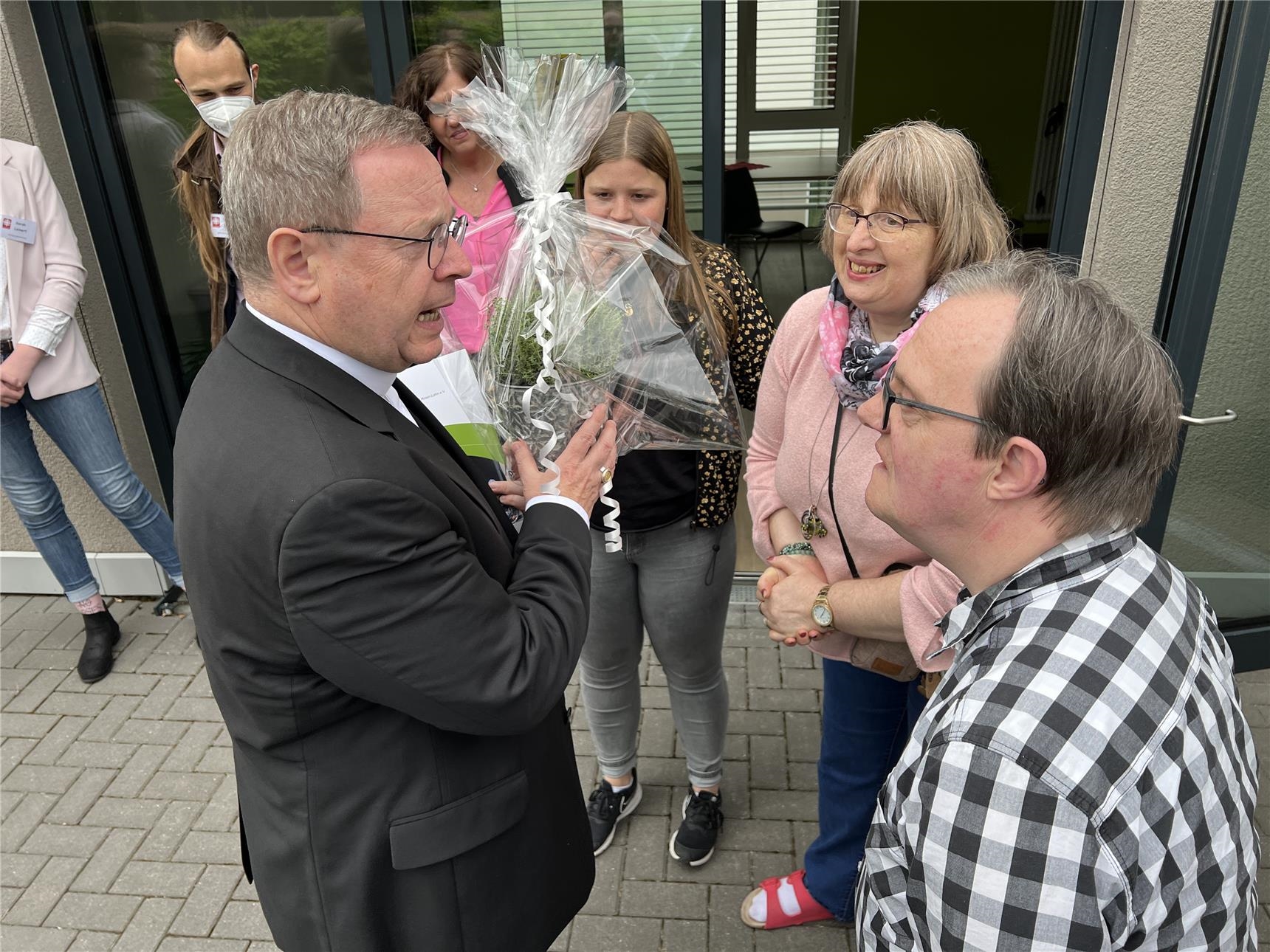 Eine Bewohnerin und ein Bewohner der Einrichtung übergeben dem Bischof eine Quendelpflanze. (Caritasverband Westerwald-Rhein-Lahn e.V. / Holger Pöritzsch)