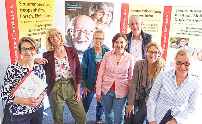 Gruppenfoto, sechs Frauen und ein Mann vor Erklärbannern verschiedener Seniorenberatungsstellen (Caritasverband Darmstadt e. V.)