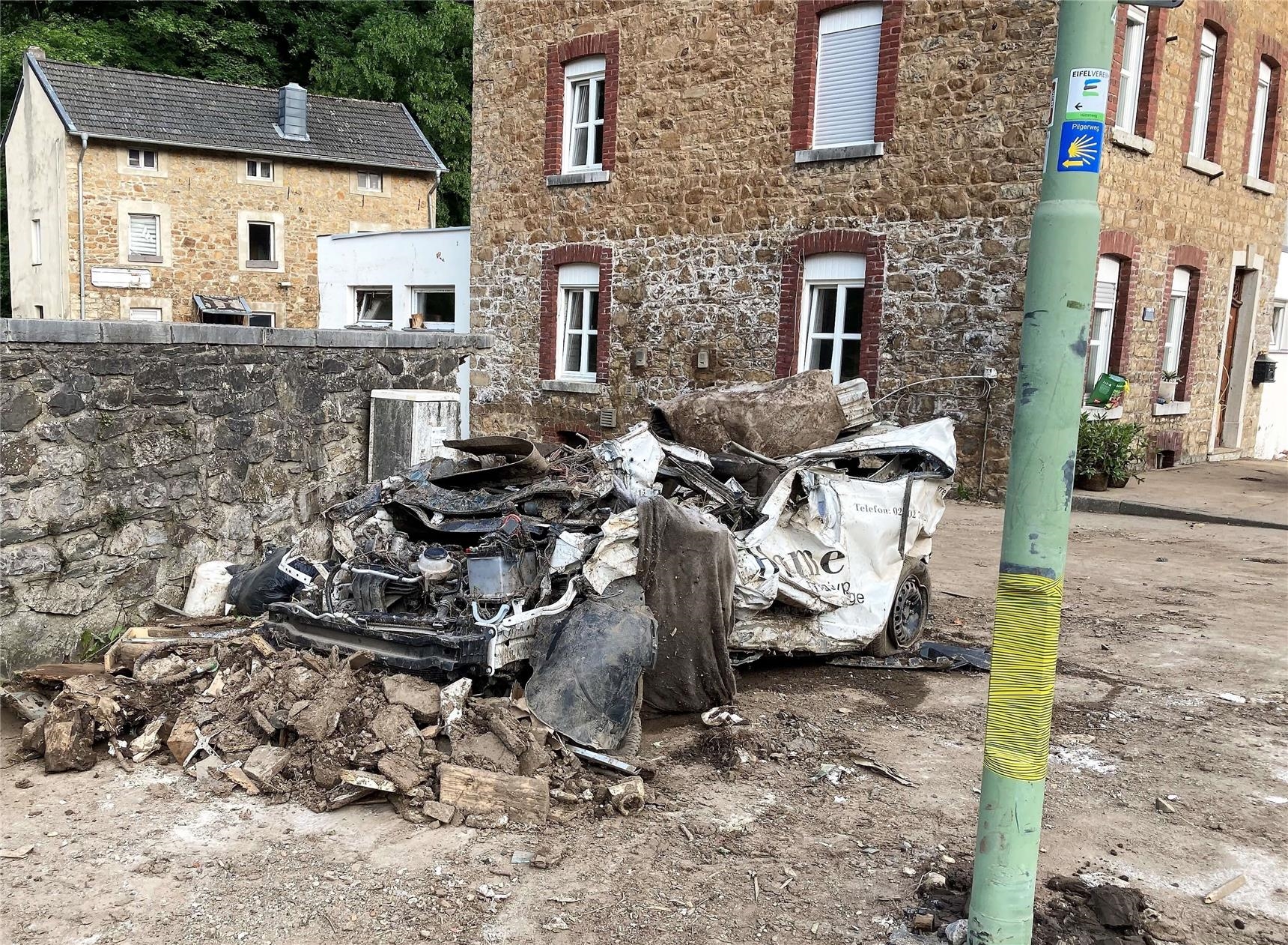 Von Flut zerstörtes Auto am Straßenrand (Caritas Düren-Jülich)