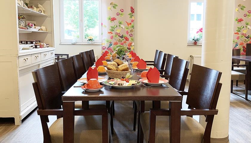 Gedeckter Frühstückstisch mit zehn Stühlen
