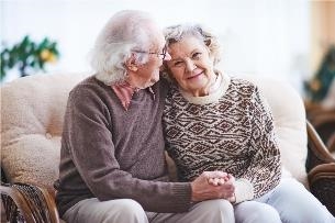 Ein älteres Paar sitzt nebeneinander auf dem Sofa