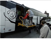Verladen eines Rollstuhls per Hebebühne in den großen Reisebus