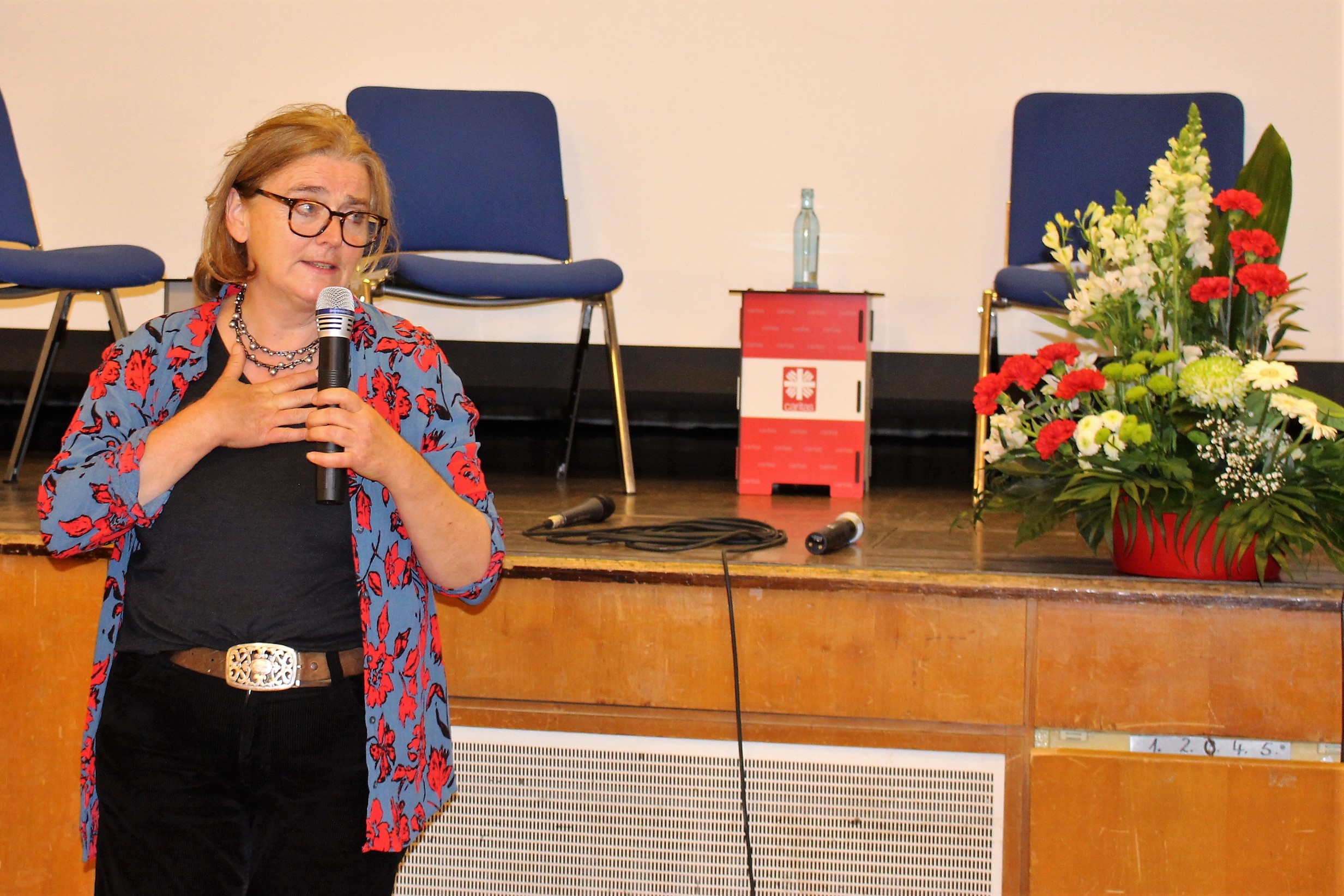 Eine Frau am Mikrofon. (Caritasverband Darmstadt e. V.)