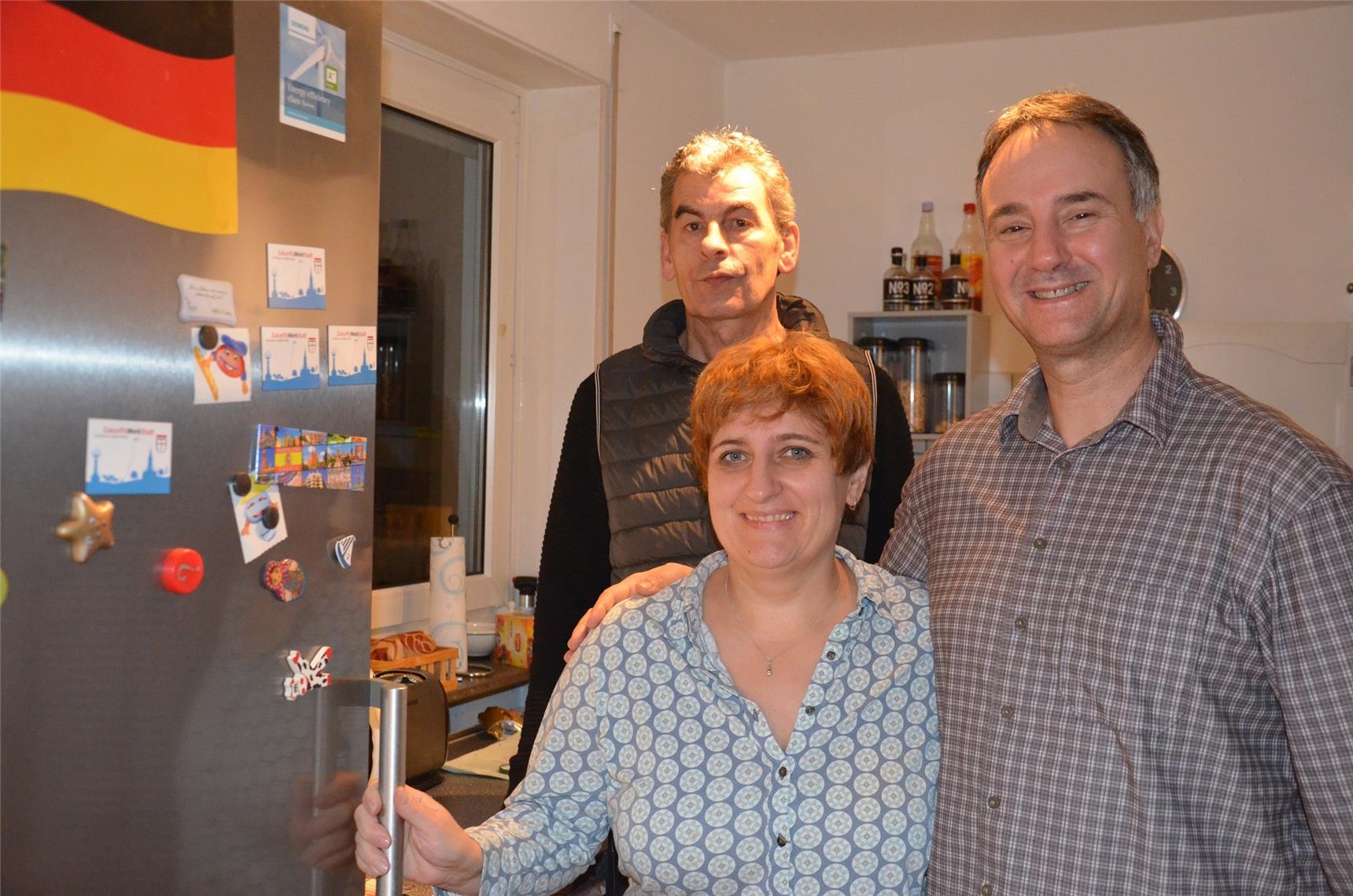 Mitarbeiter und Familie vor dem Kühlschrank (Caritas Konstanz)