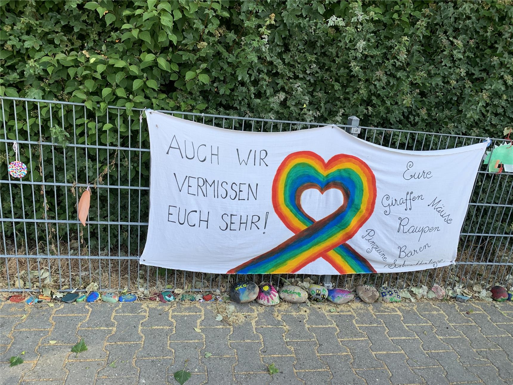 Zaun Kita Regenbogen mit Banner "Auch wir vermissen euch sehr" (© Caritasverband Worms e. V.)