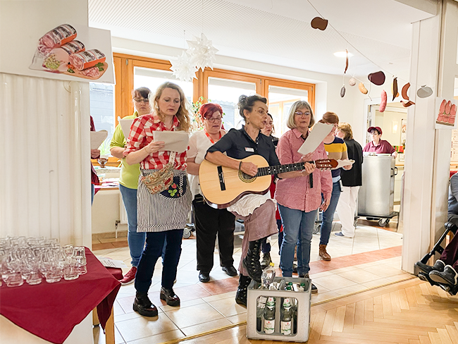 Mitarbeitende geben ein musikalisches Ständchen mit Gitarrenbegleitung 